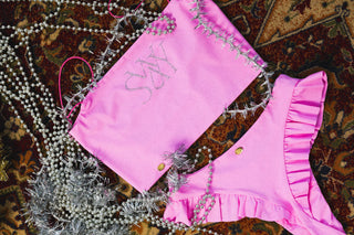 Pink polewear set with 'SWAY' branding on a textured surface with decorative elements.